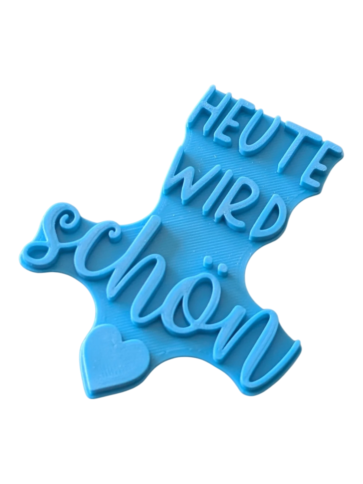Perspektivische Detailansicht des blauen Keramikstempels mit dem Spruch Heute wird schön und Herz-Symbol.
